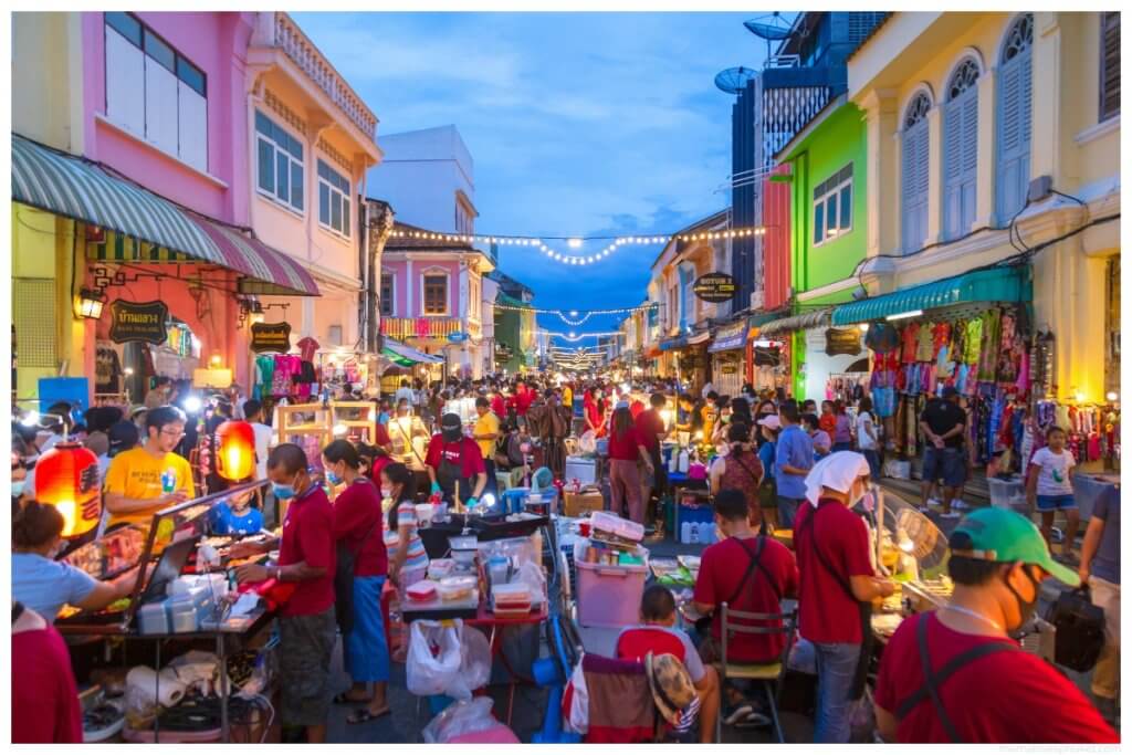 walking street market in phuket old town workers in red shirts serving food
